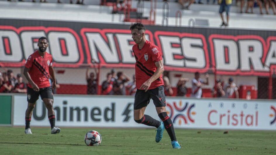 Jogador do Atlético-GO com a camisa vermelha e a bola na frente.