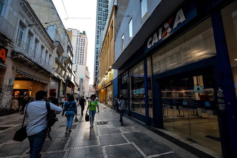 Agência do banco CAIXA em uma rua urbana movimentada