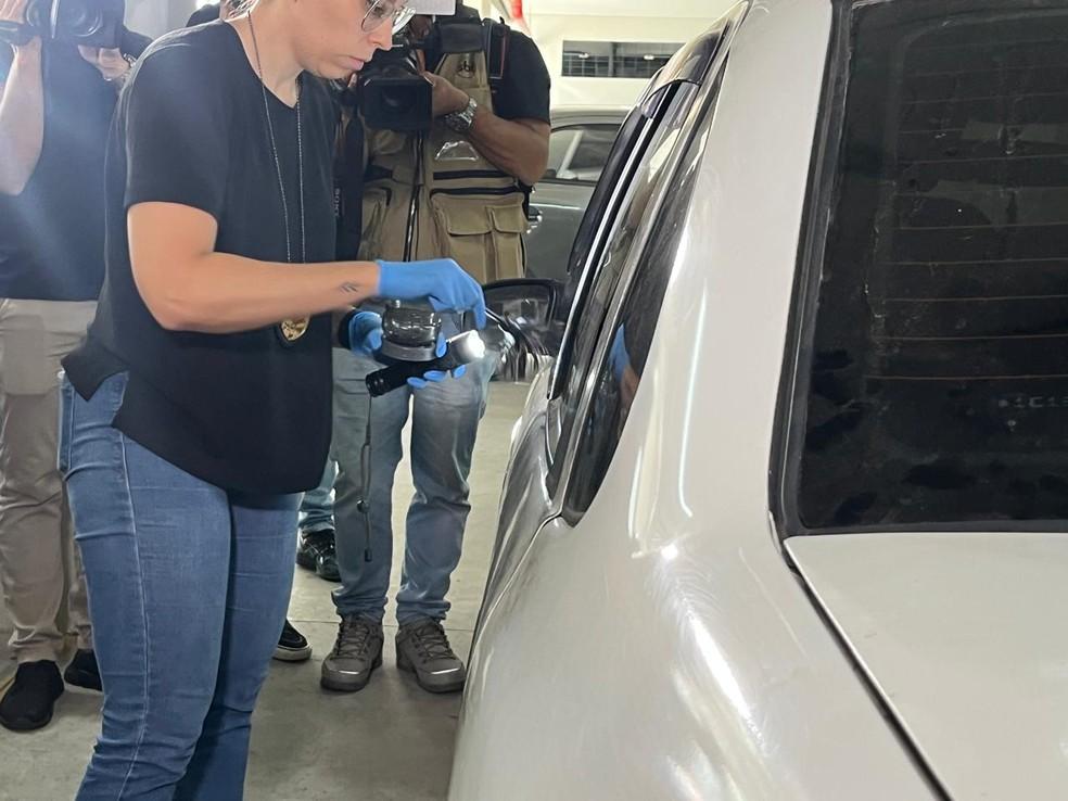 Agentes da polícia científica fazendo coletas de digitais em um dos veículos encontrados
