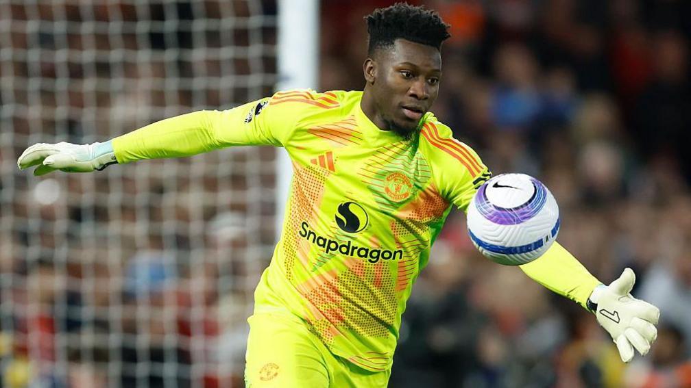 Andre Onana chuta a bola usando a camisa de goleiro do Manchester United.