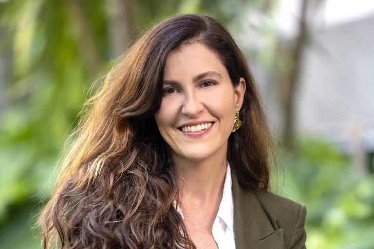 Mulher sorrindo vestindo blazer verde