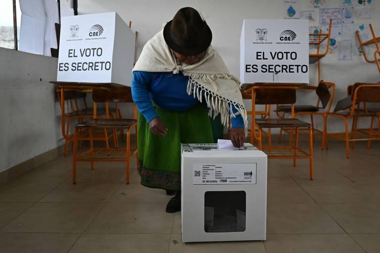 Mulher se preparando para votar em cabine eleitoral no Equador