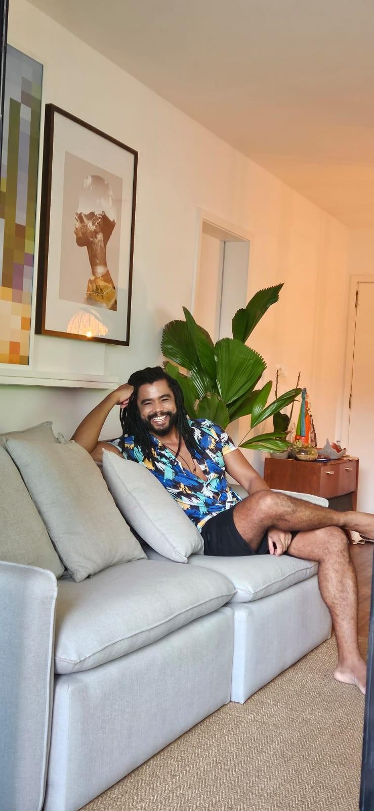 Diogo Almeida em sua sala no apartamento