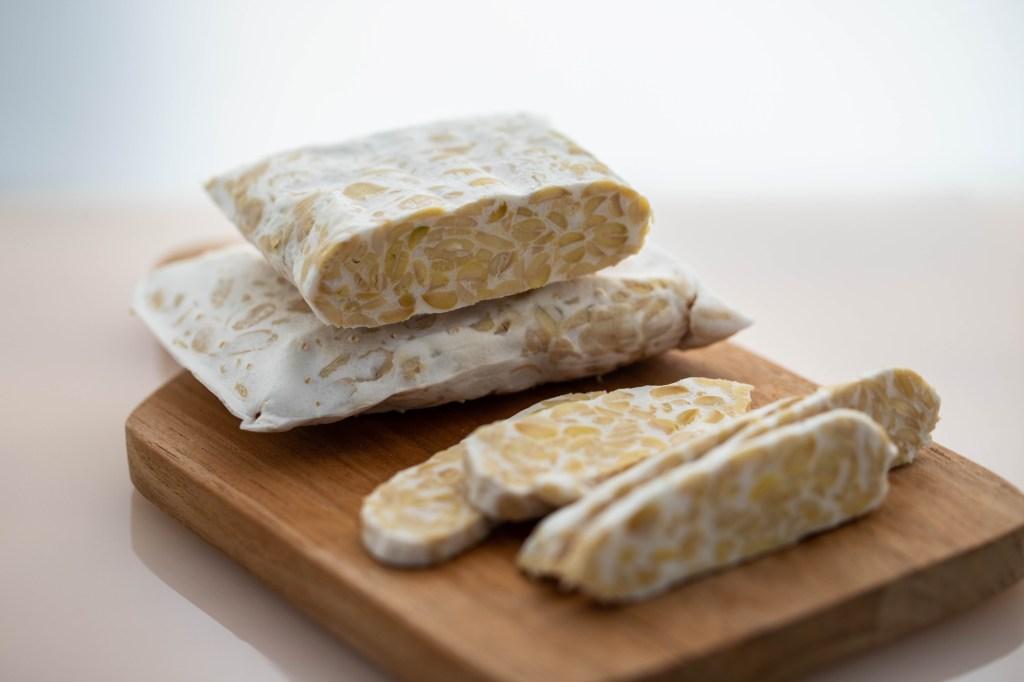 Tempeh sendo preparado, um alimento rico em probióticos.