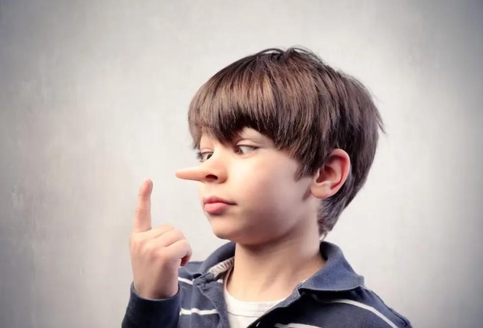 Menino com nariz grande, em alusão à história de Pinóquio.