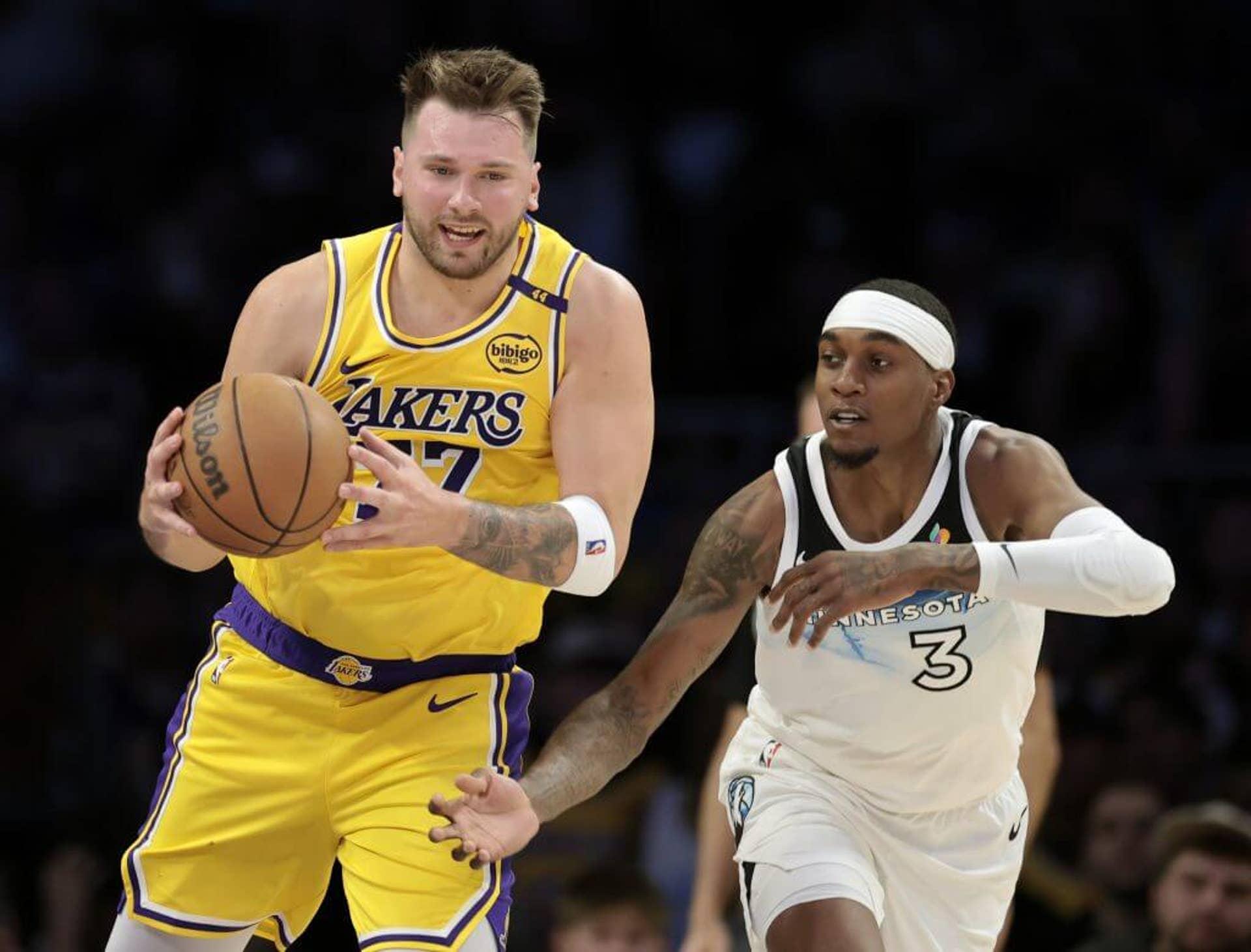 Luka Dončić dos Los Angeles Lakers e Jaden McDaniels dos Minnesota Timberwolves durante um jogo