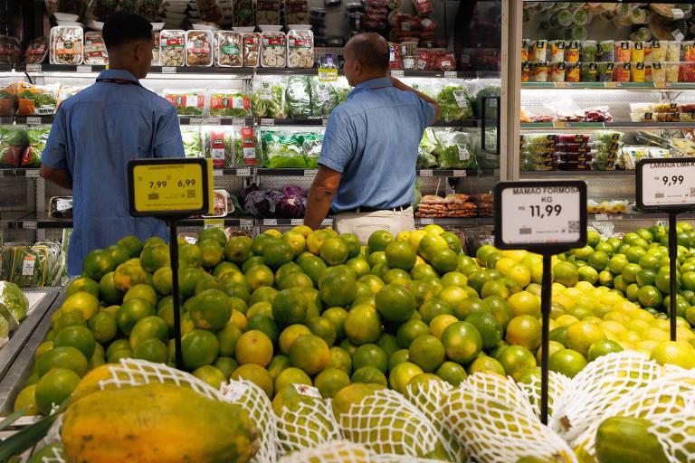 Compradores observando prateleiras com produtos em um supermercado