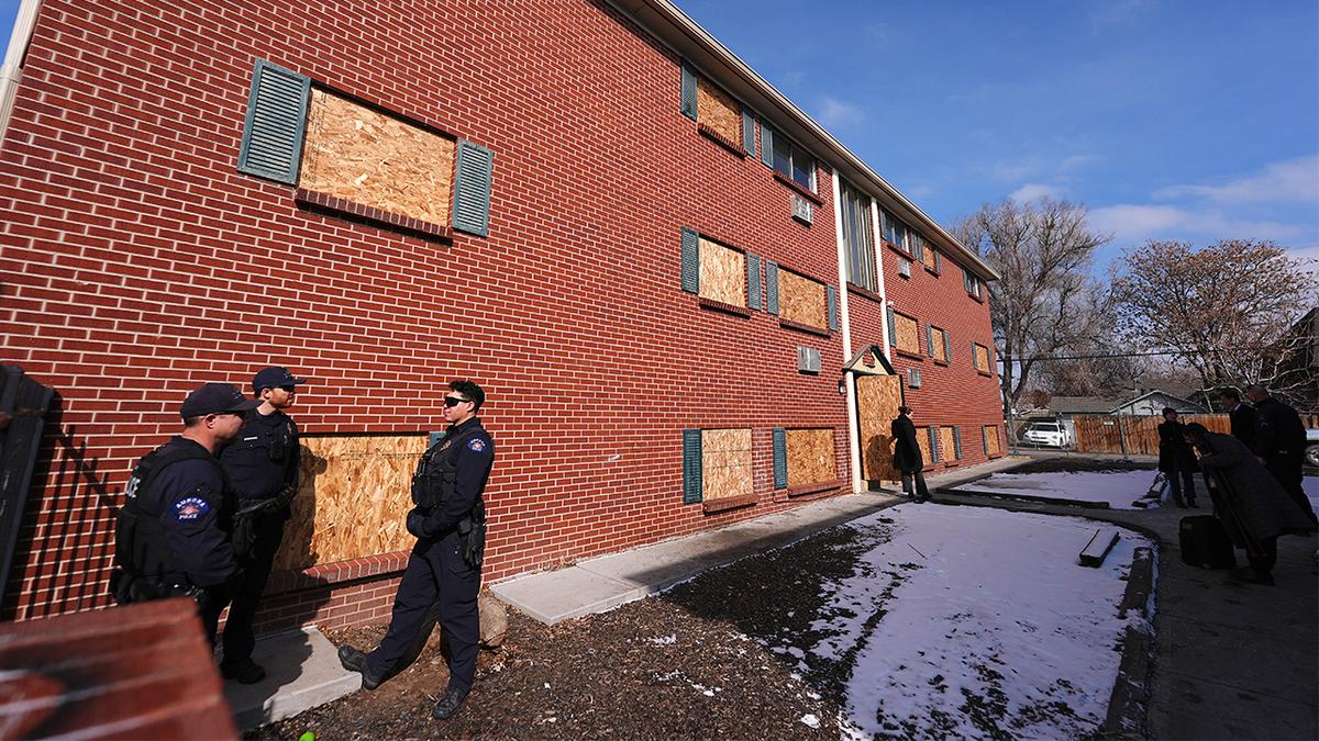 Oficiais em frente a um prédio condenado na Edge at Lowry