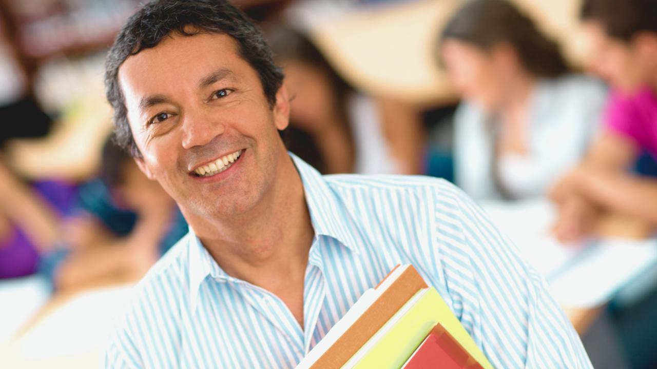 Homem segurando material didático.