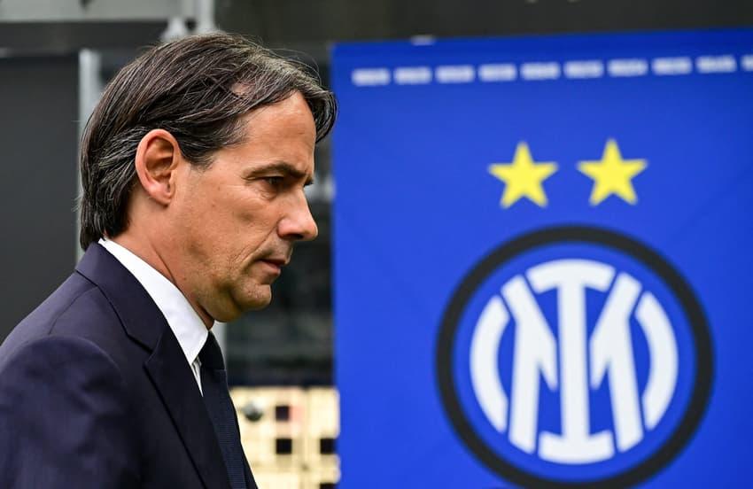 Simone Inzaghi caminha com o escudo da Inter de Milão ao fundo