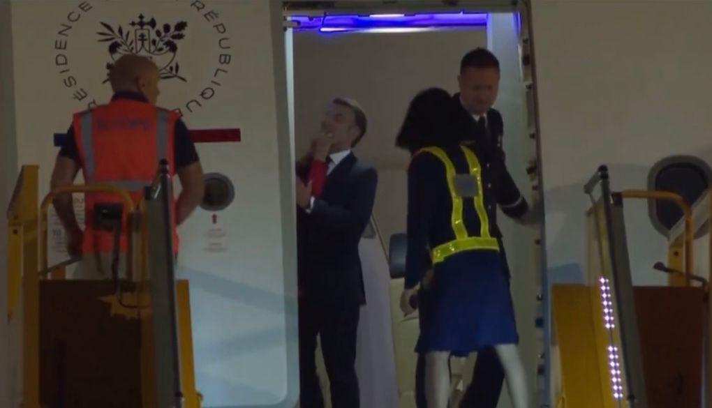 Brigitte Macron empurrando rosto de Emmanuel Macron.