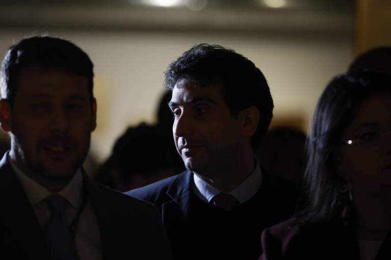 Grupo de pessoas em ambiente com pouca luz durante evento