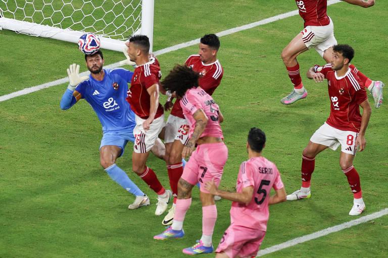 Goleiro Mohamed El Shenawy, em momento de defesa, cercado por jogadores de ambas as equipes.