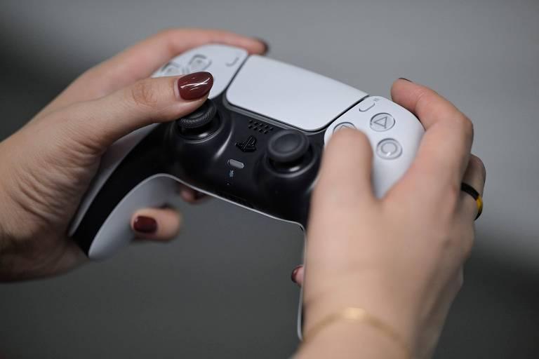 Pessoa segurando um controle de PlayStation 5