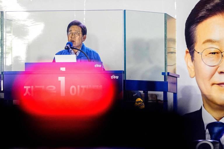 Lee Jae-myung em um evento político, falando ao microfone.