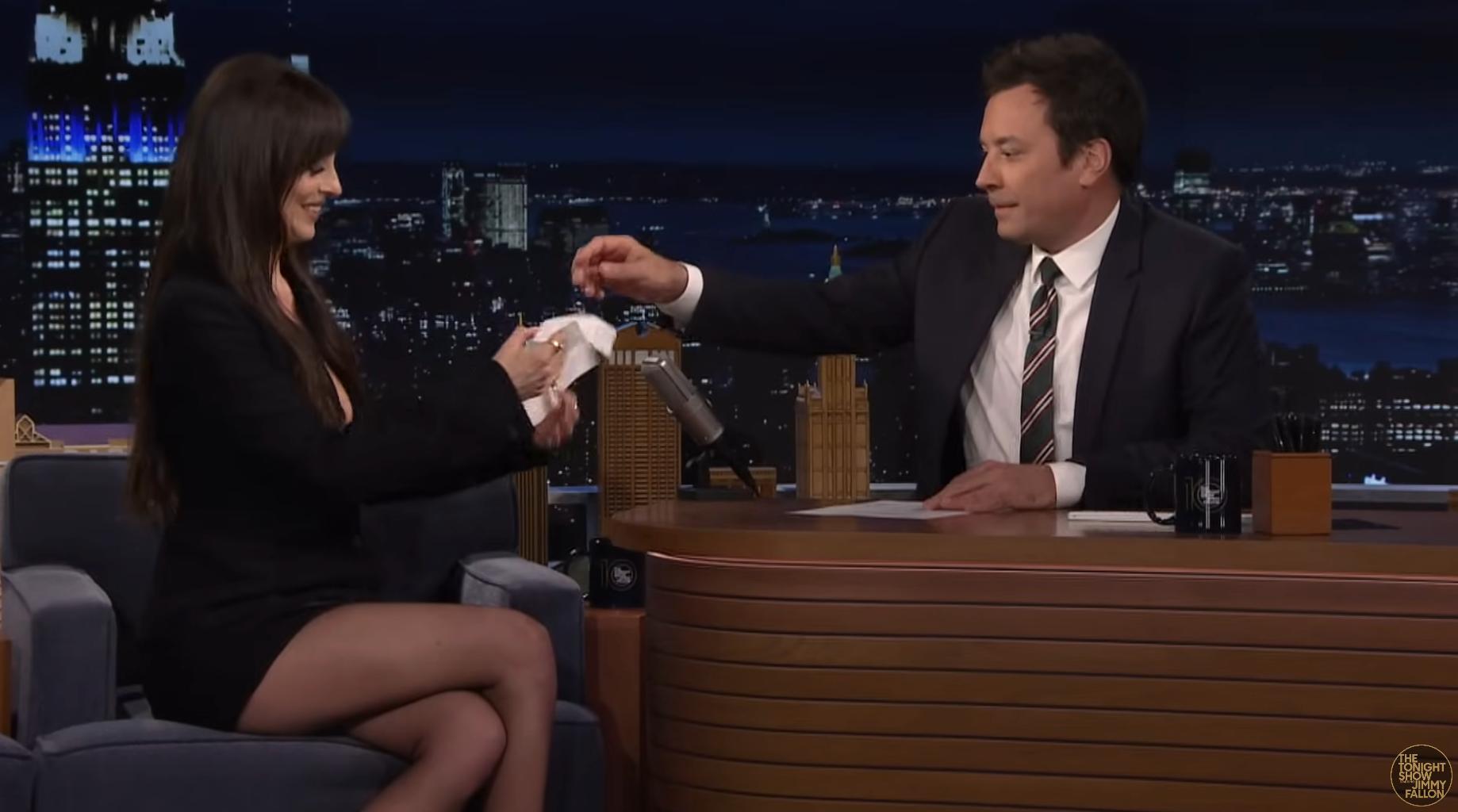 Jimmy Fallon entregando um lenço a Dakota Johnson