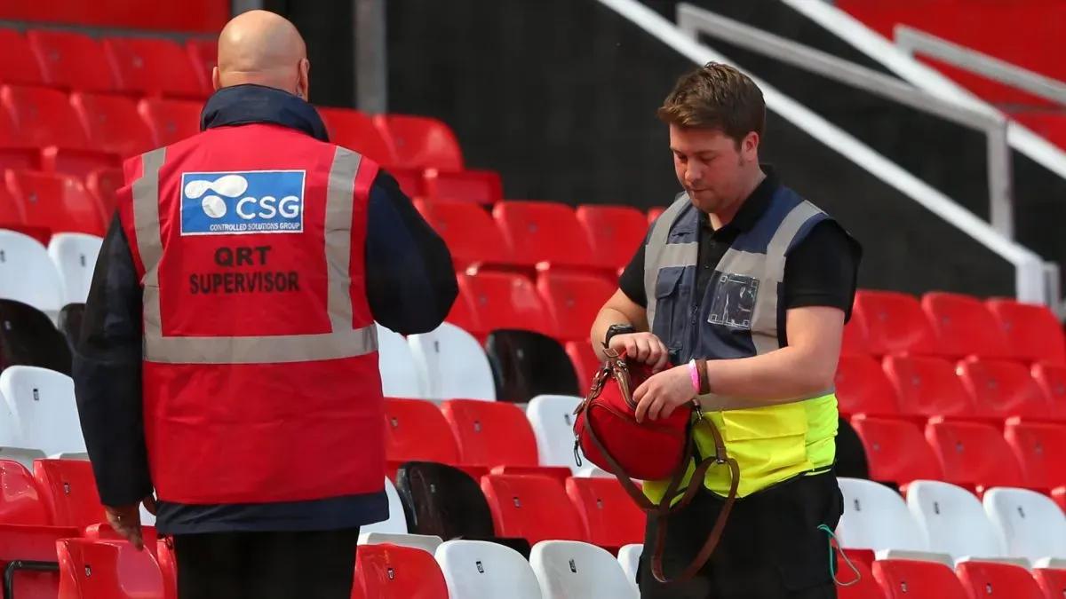 Segurança revistando uma bolsa durante um jogo da Premier League