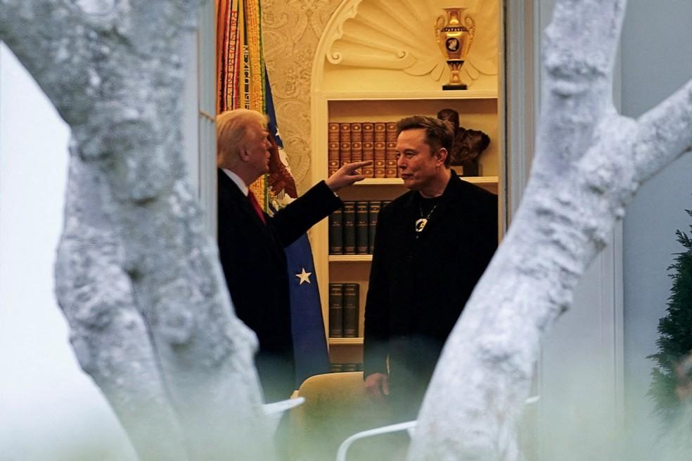 O presidente dos EUA, Donald Trump, conversa com Elon Musk com o dedo em riste.