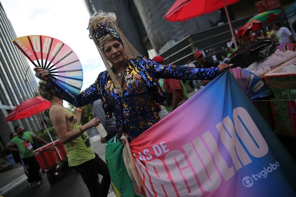 Participante da 28ª Parada LGBT+ de São Paulo exibe bandeira do orgulho gay na Avenida Paulista.