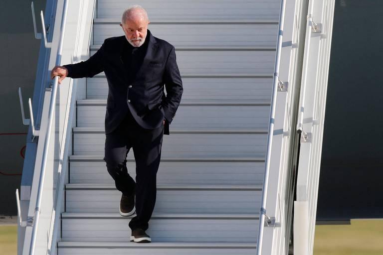 Lula descendo as escadas de um avião em aeroporto