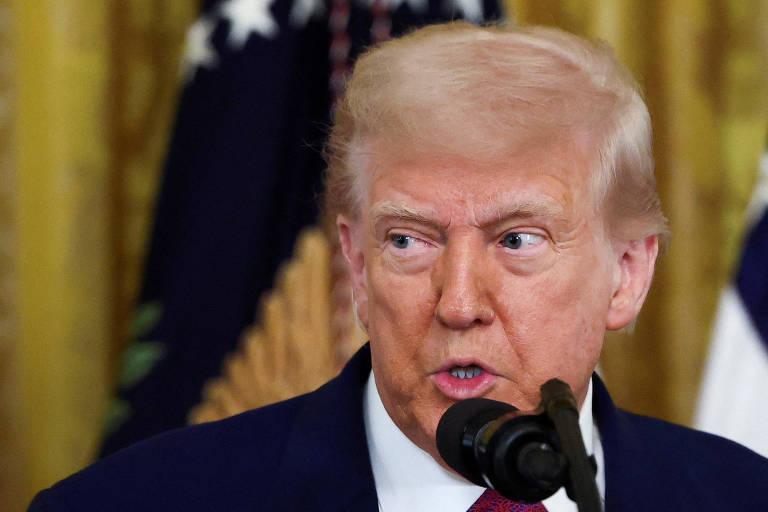 Donald Trump em evento oficial, falando em um microfone.