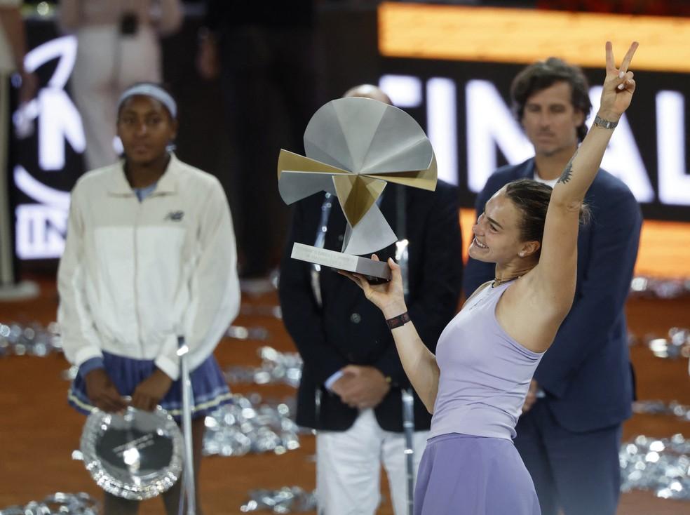 Aryna Sabalenka comemorando o título do WTA de Madrid, ao fundo, a vice-campeã Coco Gauff