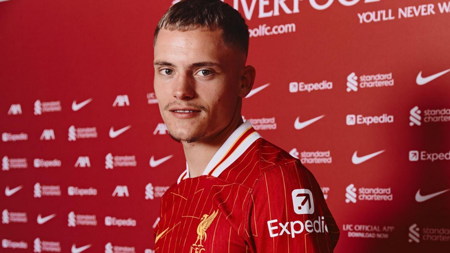 Florian Wirtz poses in a Liverpool shirt