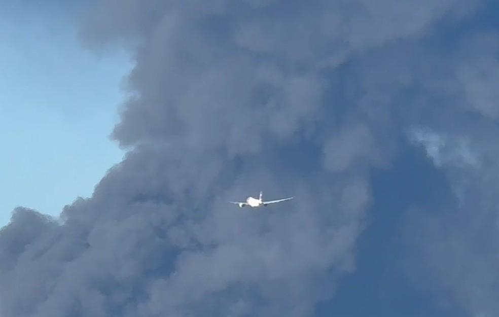 Avião passa por coluna de fumaça provocada por incêndio em indústria em Guarulhos, na Grande SP