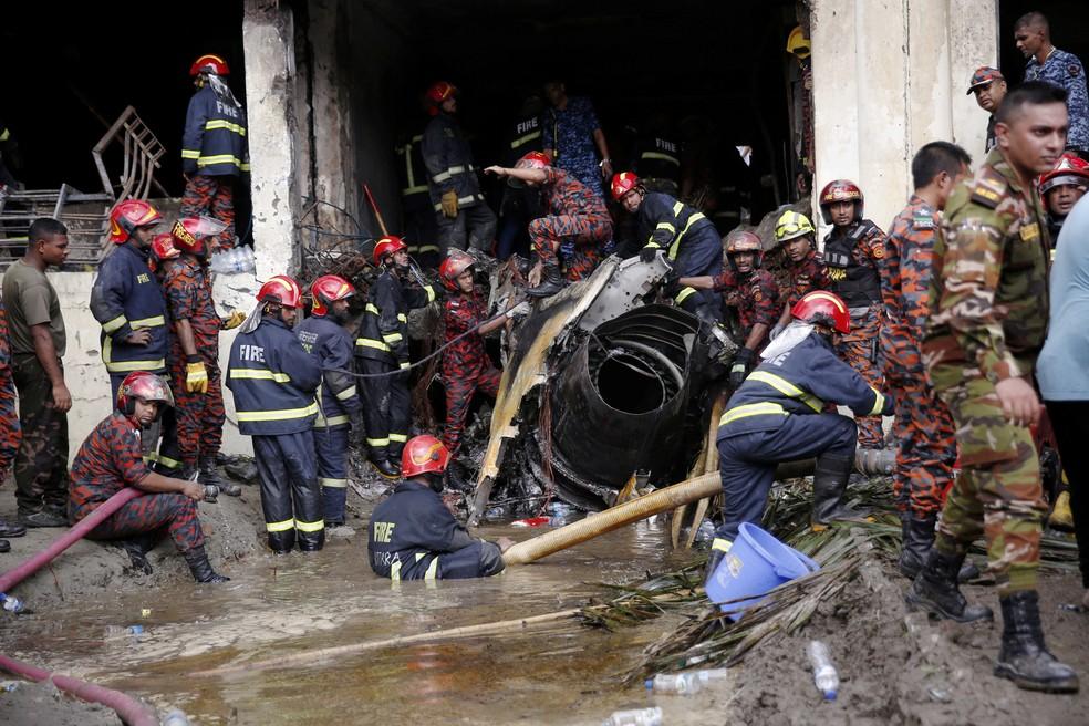 Bombeiros trabalham nos destroços do avião em Daca