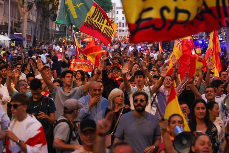 Multidão em uma manifestação na Espanha levantando bandeiras