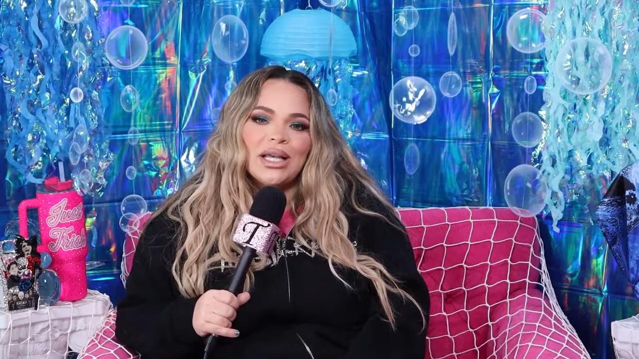 Trisha Paytas segurando um microfone em um ambiente decorado