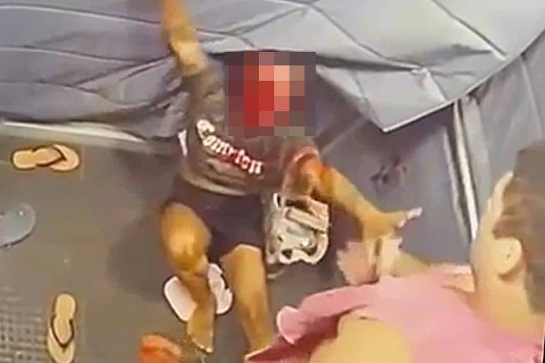 Cenas do ataque dentro do elevador, mostrando uma mulher ferida e um homem ao fundo