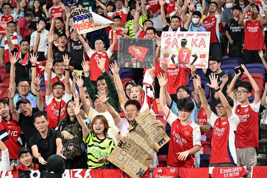 Torcedores do Arsenal torcem pela equipe durante uma sessão de treinamento em Hong Kong.