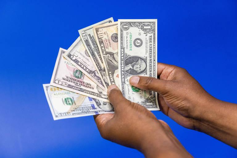 Notas de dinheiro dos Estados Unidos em uma mão