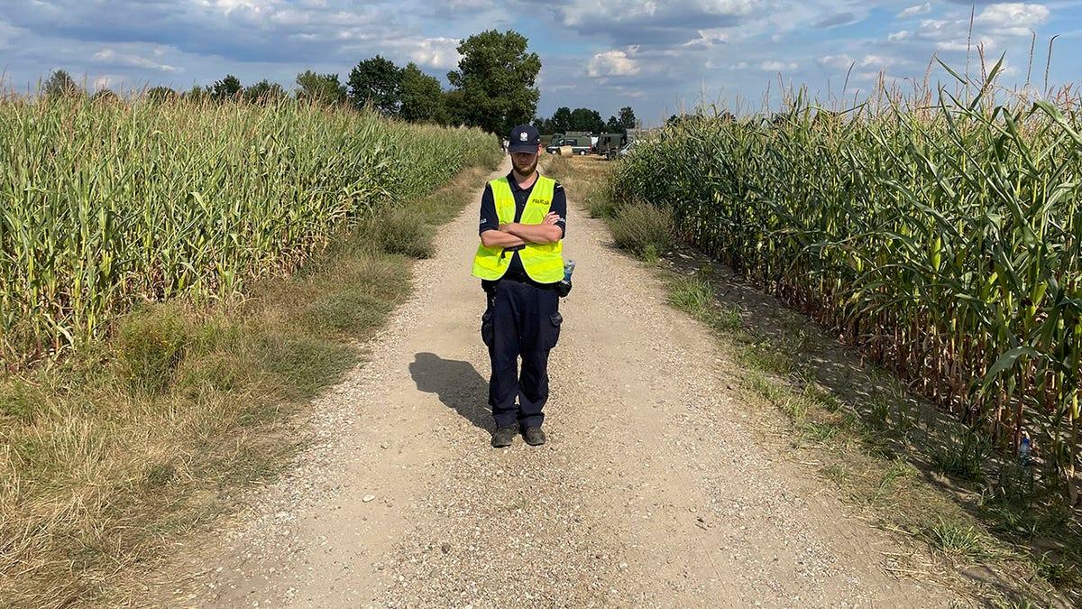 Um policial polonês no local do acidente do drone russo.