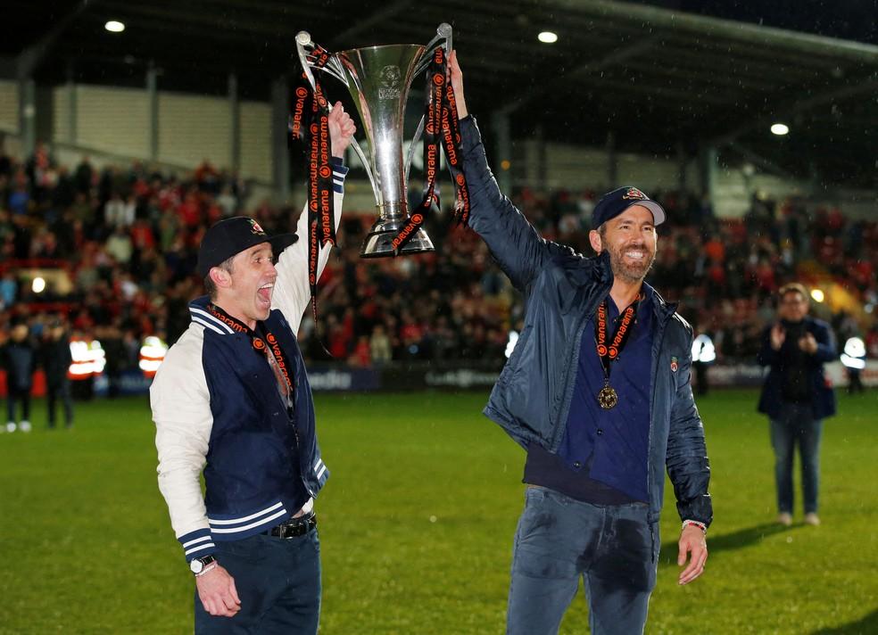 Rob McElhenney e Ryan Reynolds, atores donos do Wrexham, levantam a taça da quinta divisão inglesa — Foto: Reuters