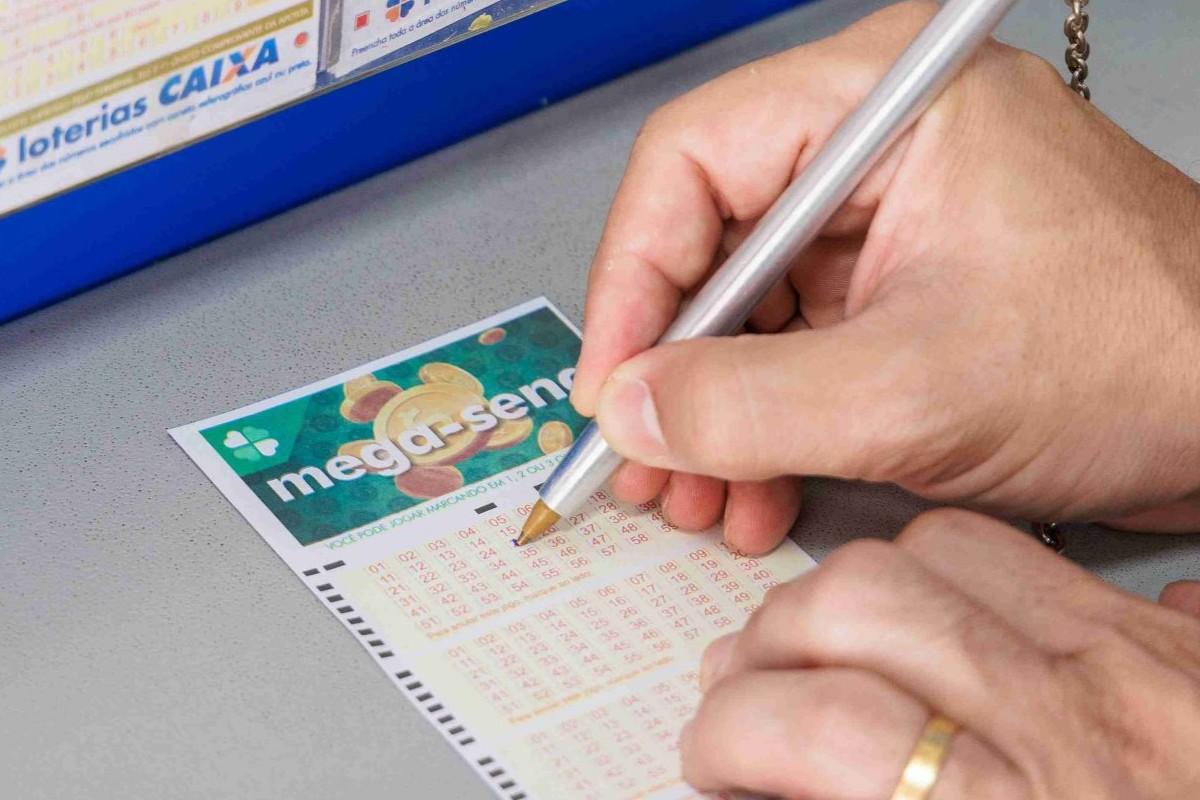 Pessoa marcando números em uma aposta de loteria Mega Sena