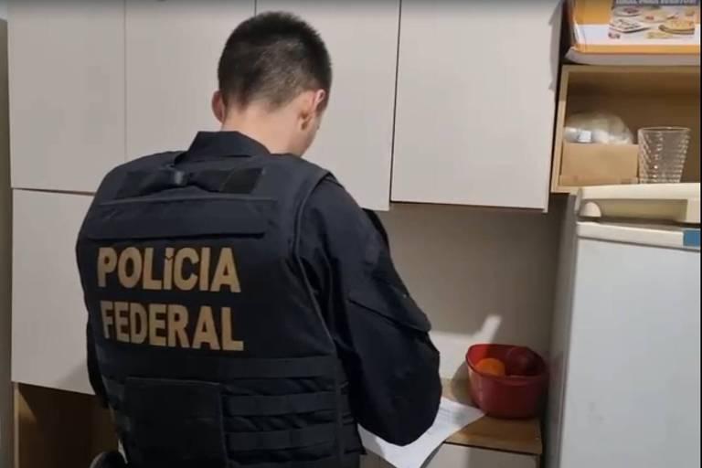 Agente da Polícia Federal observa documento