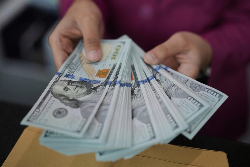 Funcionário de banco em Jacarta, na Indonésia, conta notas de dólar