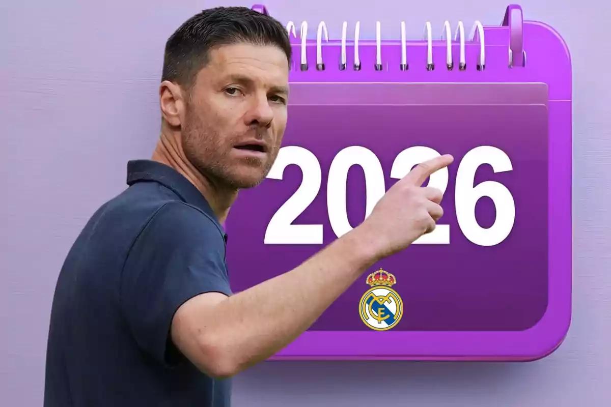 Man pointing at a purple calendar with the number 2026 and the Real Madrid crest.