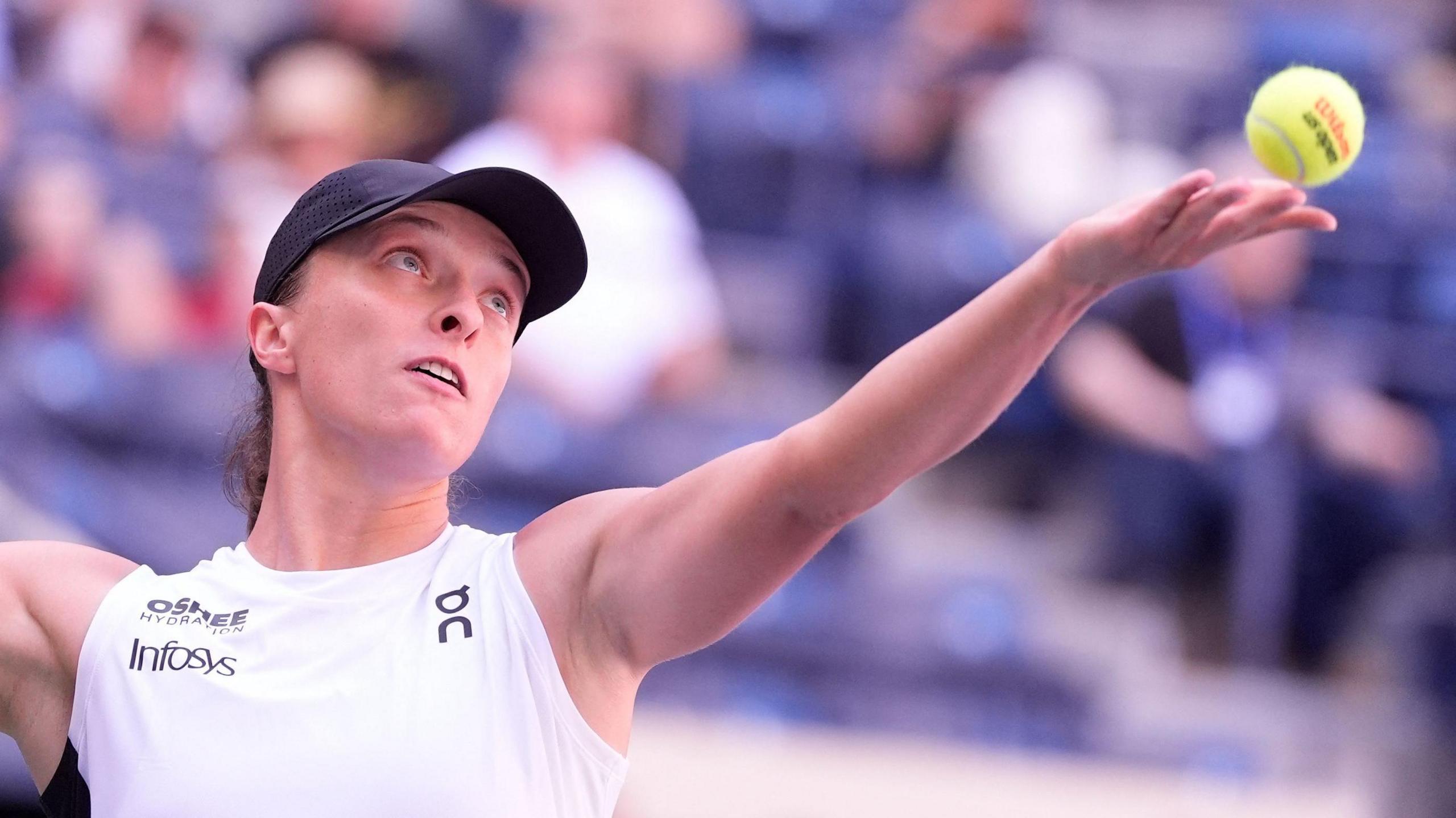 Iga Swiatek servindo a bola durante sua partida de primeira rodada no US Open no Arthur Ashe Stadium.