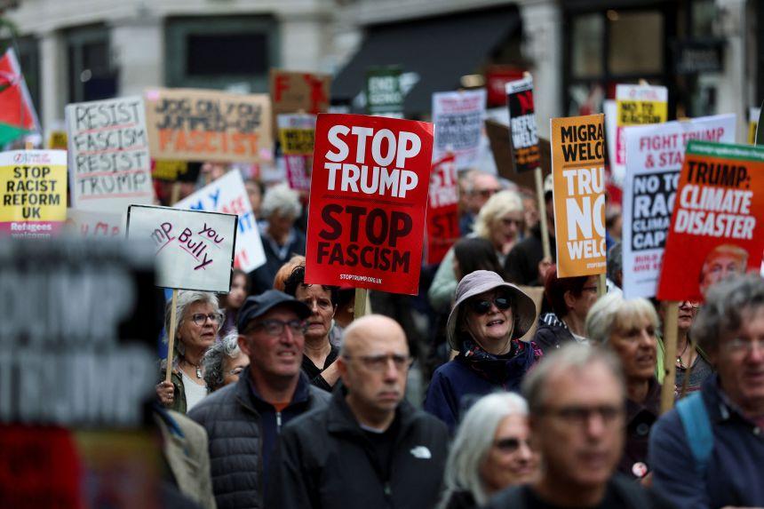 Manifestantes seguram cartazes no protesto 'Trump Não É Bem-vindo' durante a visita do presidente dos EUA.