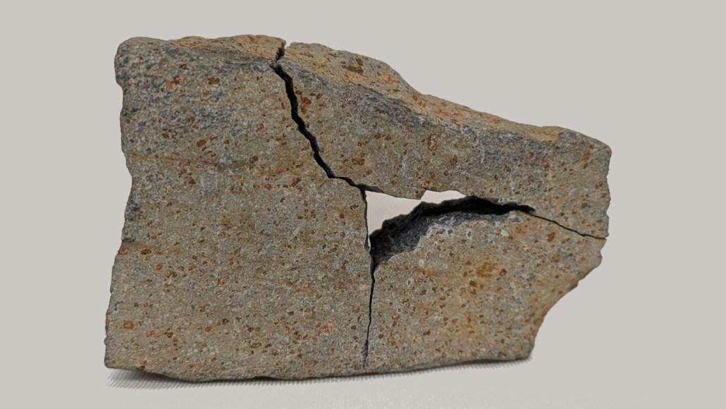Uma rocha cinza com manchas de ferrugem