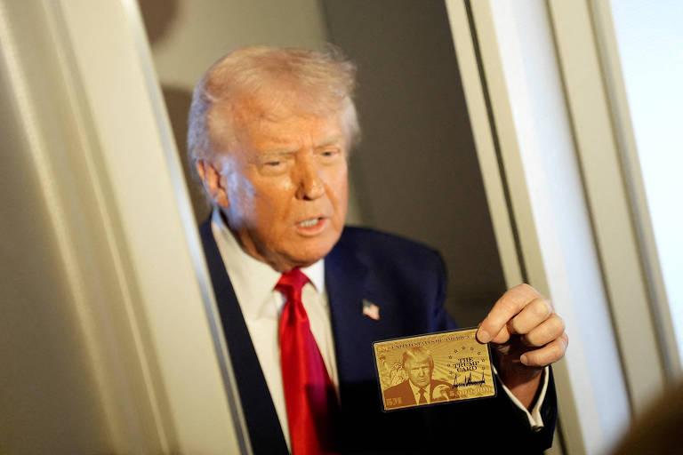 Donald Trump segurando um cartão dourado