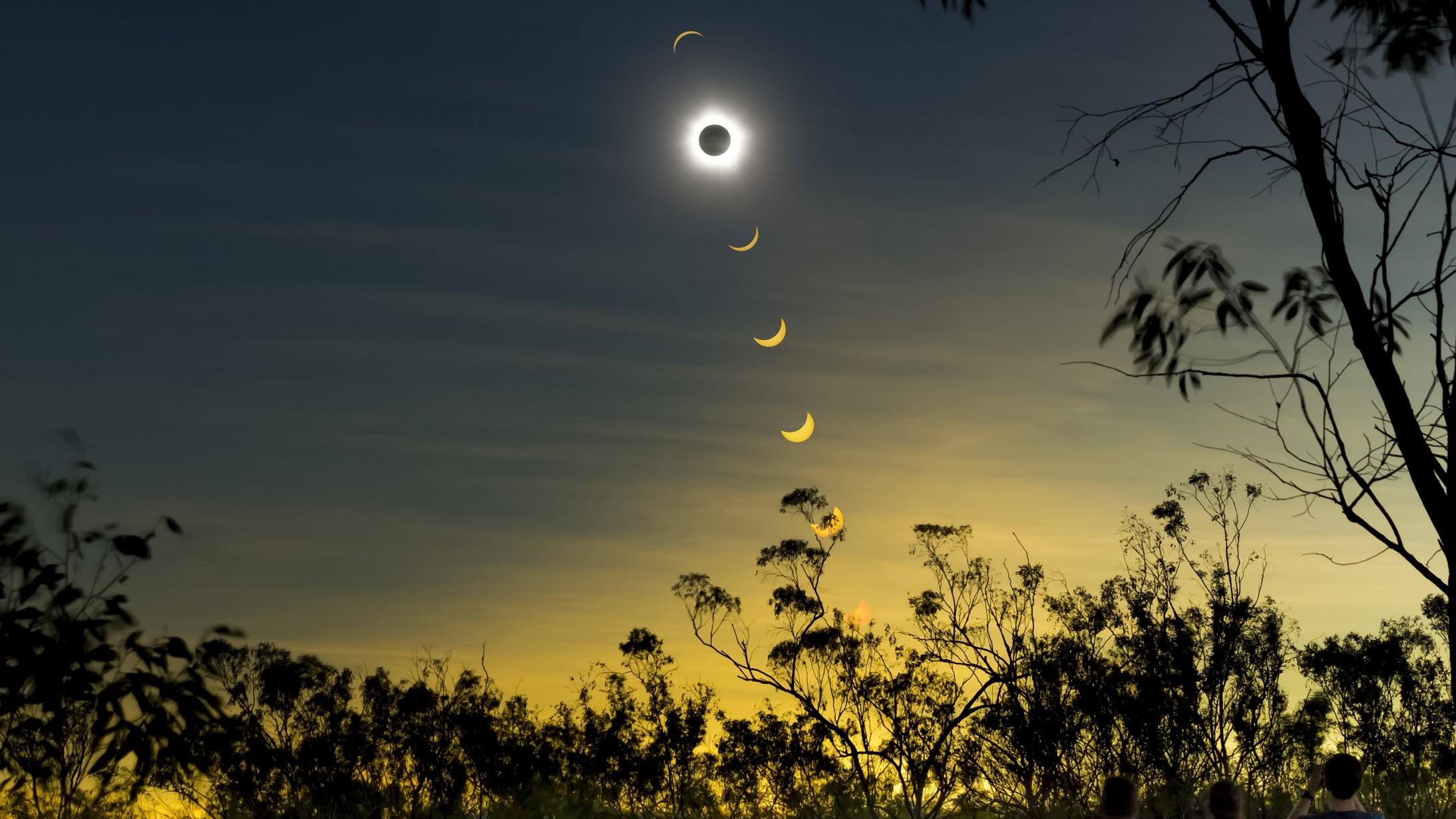 Composite de um eclipse solar com observadores no primeiro plano