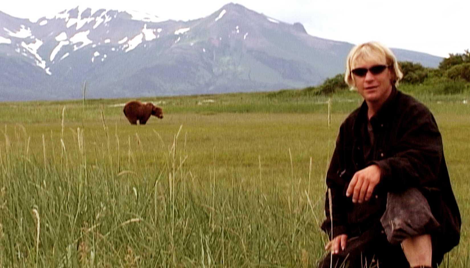 Timothy Treadwell posando em frente a um urso em Grizzly Man.
