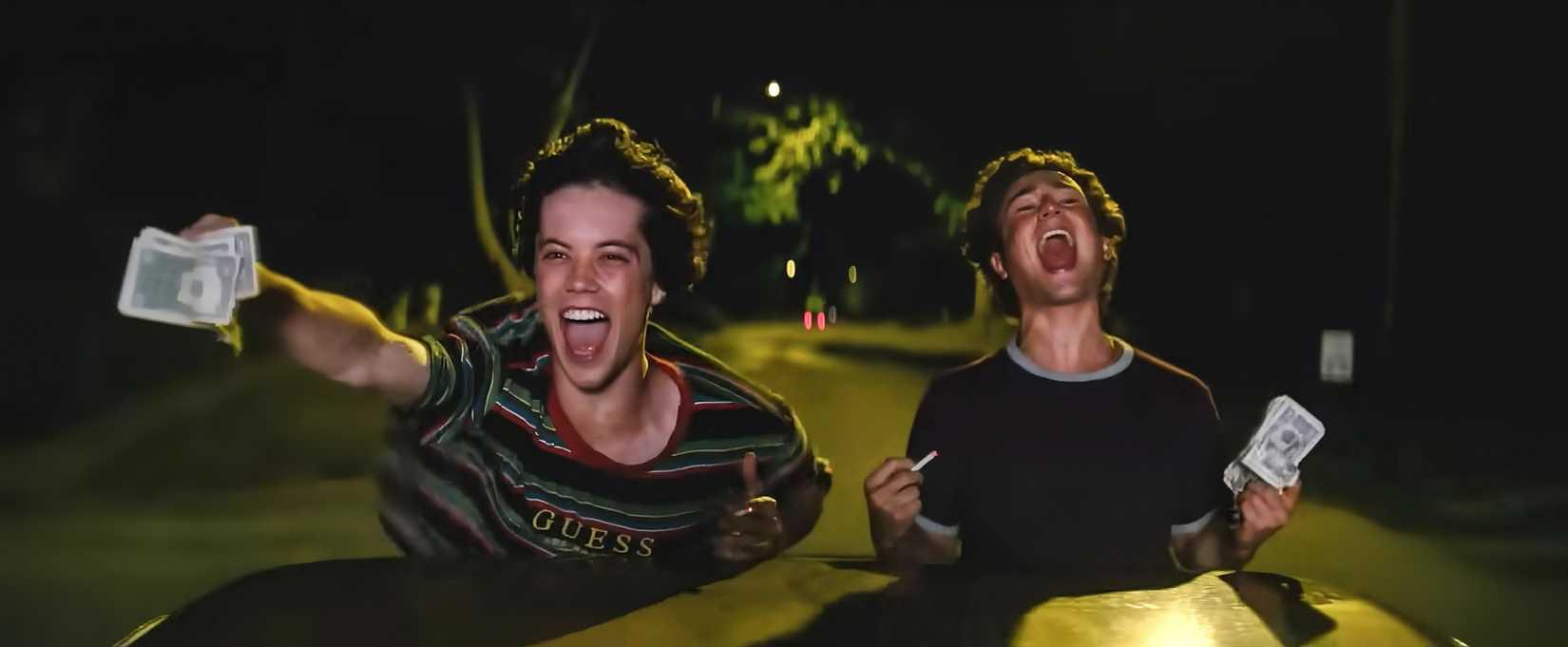 Os meninos de Snack Shack comemorando em um carro com dinheiro nas mãos.