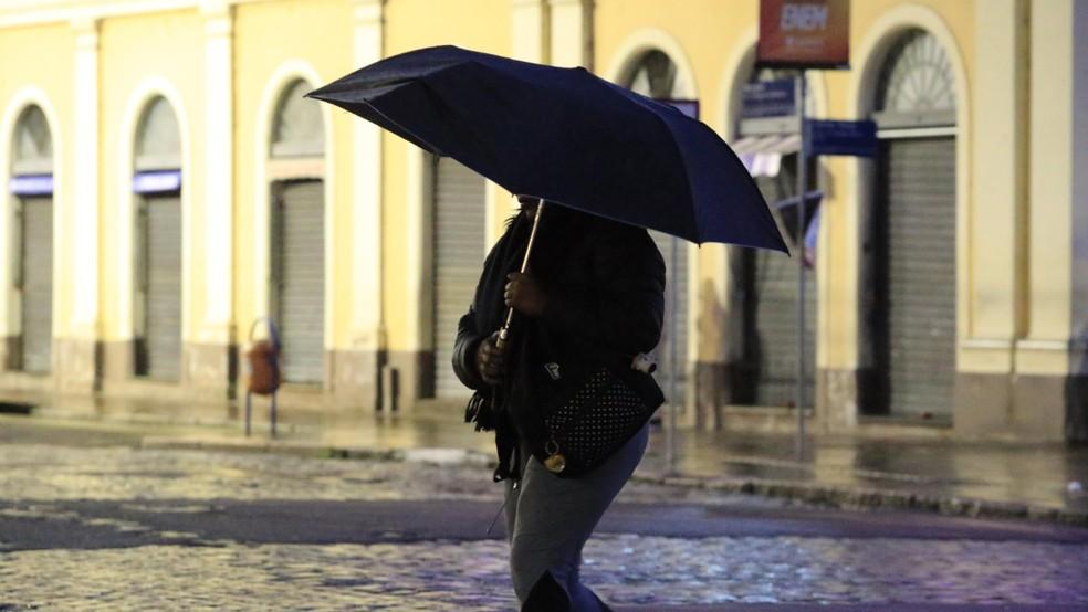 Mulher com guarda-chuva em Porto Alegre.
