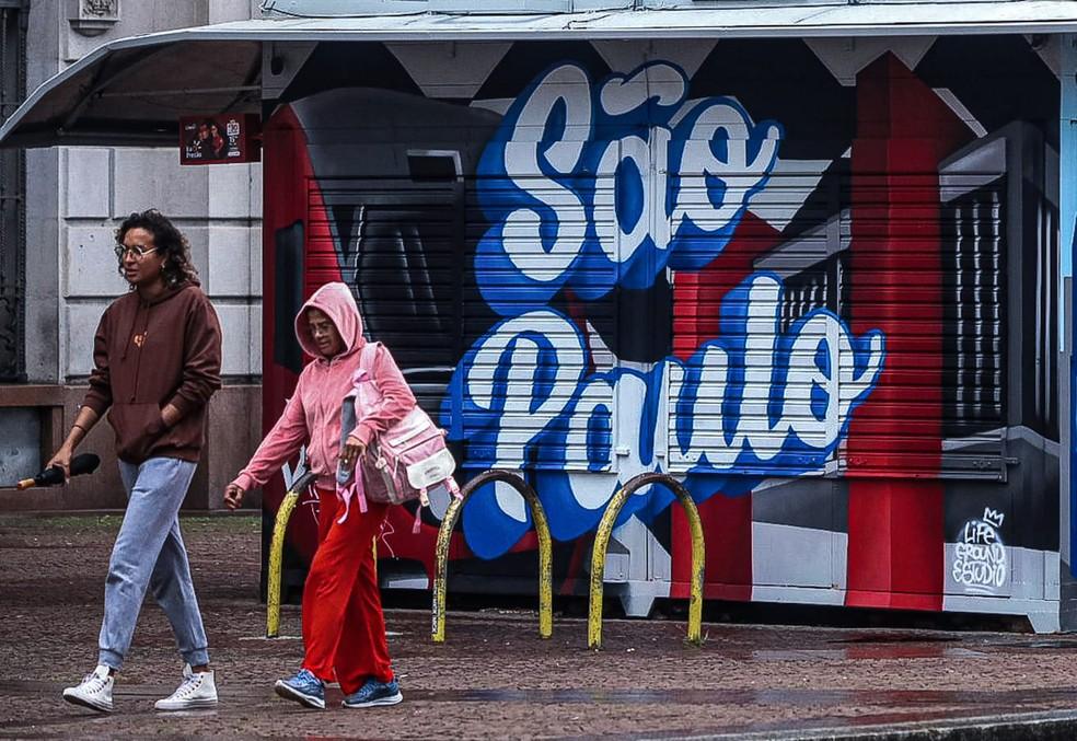 Pedestres se protegem do frio e da garoa na região central de São Paulo