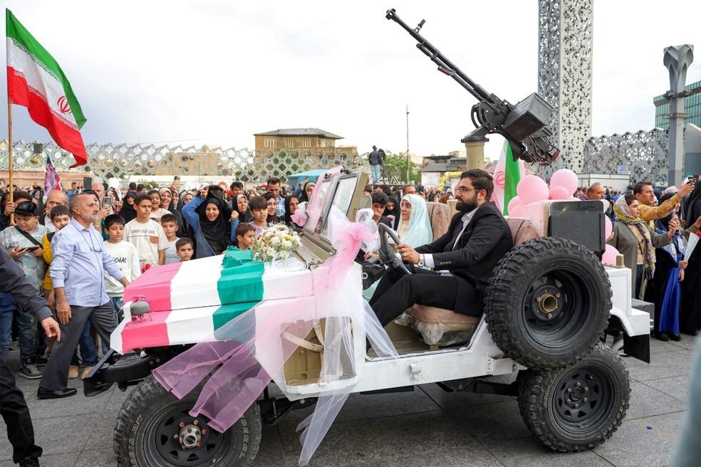 Casal chega para cerimônia de casamento coletivo na praça de Iman Hussein, em Teerã, no Irã, em 18 de maio de 2026.